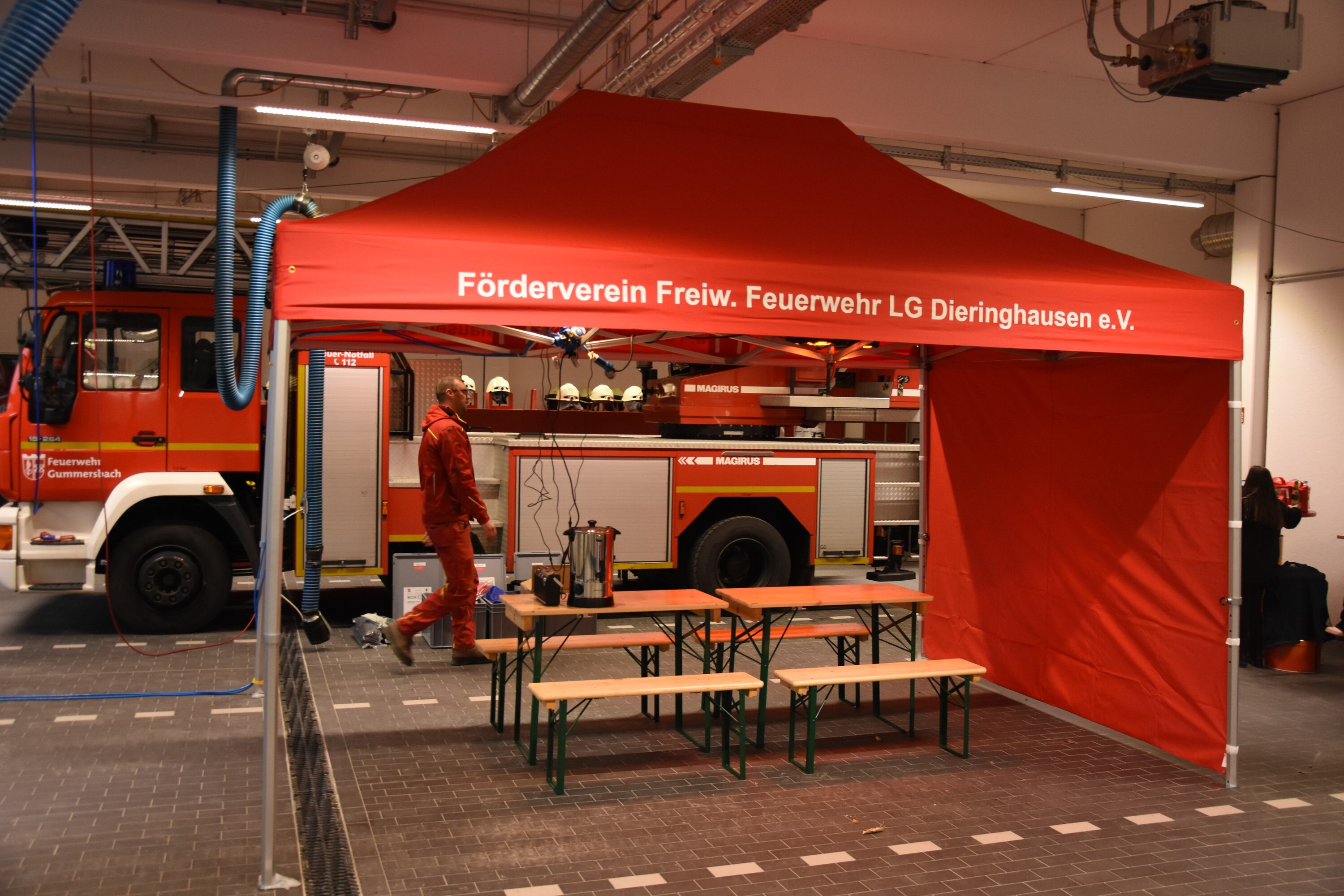 Duratent Faltpavillon mit Seitenwand und Bierzeltgarnituren vor einem Löschfahrzeug