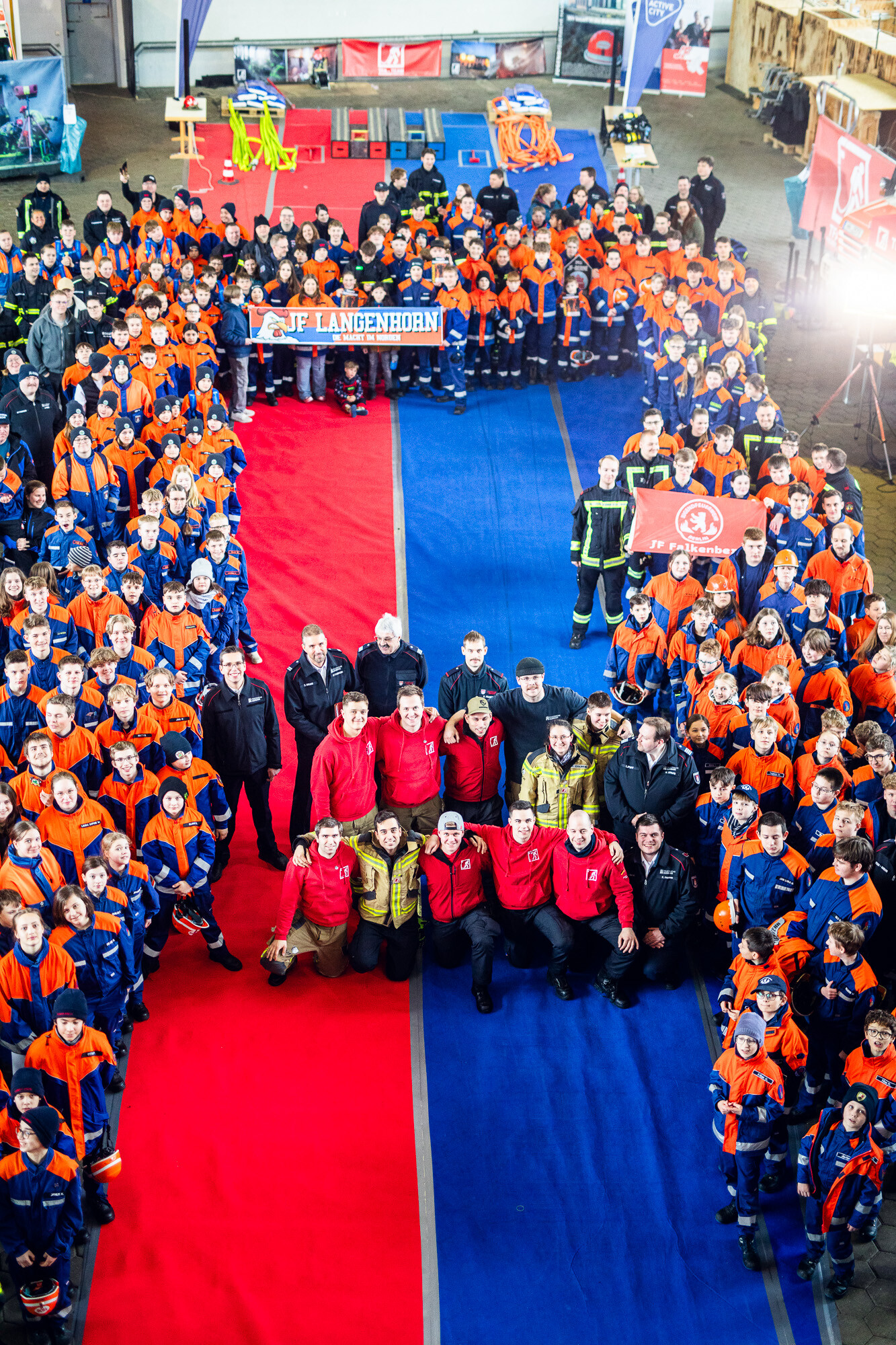Gruppenfoto der Teilnehmenden auf dem roten und blauen Teppich